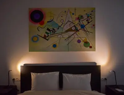 a painting hanging above a bed with two pillows at Glyfada Maisonette by Taurus in Athens