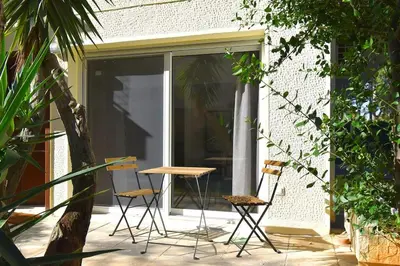 a patio with chairs and a table in front of a window at Glyfada Maisonette by Taurus in Athens