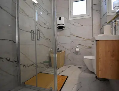 a bathroom with a shower and a toilet and a sink at Glyfada Maisonette by Taurus in Athens