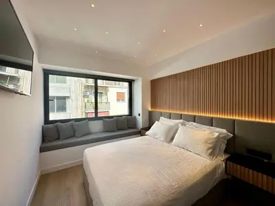 a bedroom with a large bed and a window at BlueMotion - CruiseHub 1B in Piraeus