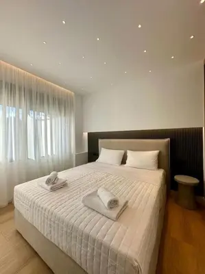 a bedroom with a large bed with towels on it at BlueMotion - CruiseHub 3B in Piraeus