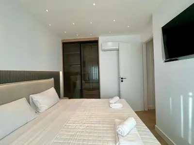 a bedroom with a bed and a flat screen tv at BlueMotion - CruiseHub 3B in Piraeus