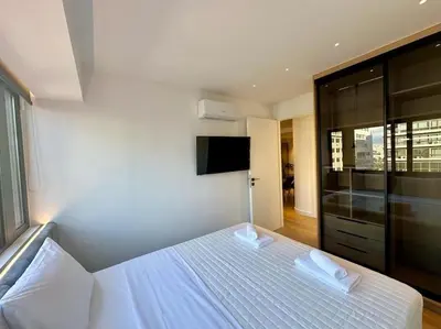 a bedroom with a white bed with two towels on it at BlueMotion - CruiseHub 3B in Piraeus