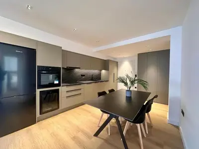 a dining room with a table and a kitchen at BlueMotion - CruiseHub 3B in Piraeus