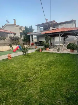 a house with a yard with pumpkins on the lawn at Seaside Luxury Apartments in Porto Rafti