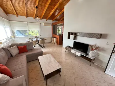 a living room with a couch and a tv at Seaside Luxury Apartments in Porto Rafti