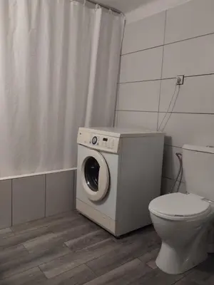 a washing machine in a bathroom with a toilet at Комнаты отдыха in Athens