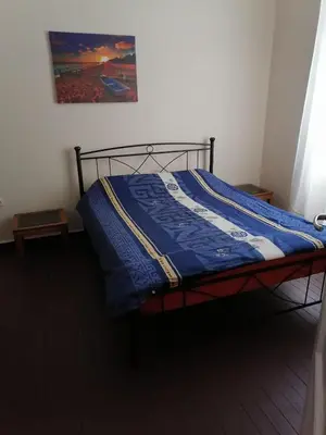 a bed with a blue comforter in a room at Комнаты отдыха in Athens