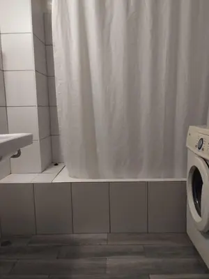 a bathroom with a shower curtain and a toilet at Комнаты отдыха in Athens