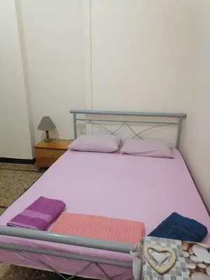 a bedroom with a bed with pink and purple blankets at Комнаты отдыха in Athens