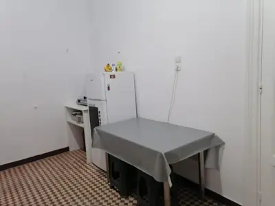a small kitchen with a table and a refrigerator at Комнаты отдыха in Athens