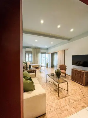 a living room with a couch and a flat screen tv at Apartment near Metro + Port in Piraeus