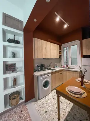 a kitchen with a washing machine and a table at Apartment near Metro + Port in Piraeus
