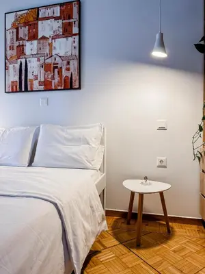 a bedroom with a bed and a table at Apartment near Metro + Port in Piraeus
