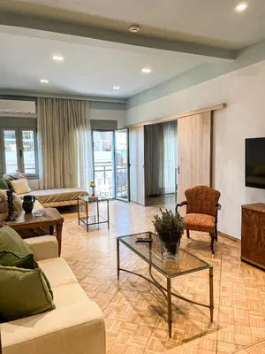 a living room with a couch and a table at Apartment near Metro + Port in Piraeus