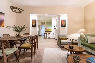 a living room with a table and chairs at Artsy Spacious Cozy Apartment in Glyfada Center in Athens