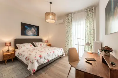 a bedroom with a bed and a desk and a desk at Artsy Spacious Cozy Apartment in Glyfada Center in Athens