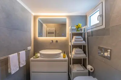 a bathroom with a sink and a mirror at Artsy Spacious Cozy Apartment in Glyfada Center in Athens