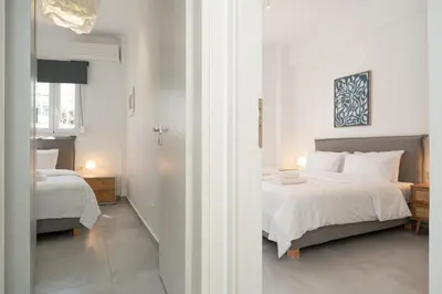 a bedroom with two beds with white sheets at Athenian Gem, Fully Renovated 2 Bedroom Apartment Near Acropolis in Athens