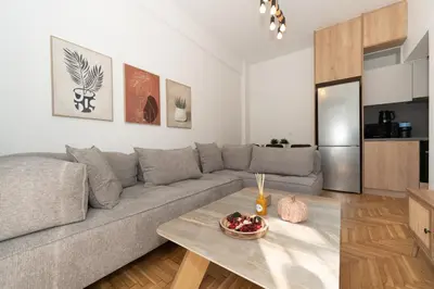 a living room with a gray couch and a table at Athenian Gem, Fully Renovated 2 Bedroom Apartment Near Acropolis in Athens