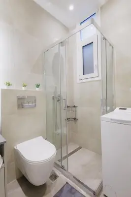 a bathroom with a toilet and a glass shower at Modern & Stylish 1 BDR Apartment in Athens