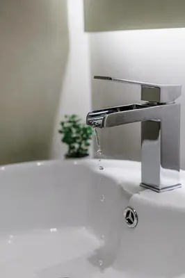 a bathroom sink with a faucet and a plant at Modern & Stylish 1 BDR Apartment in Athens