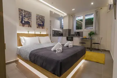 a bedroom with a large bed and a kitchen at Modern & Stylish 1 BDR Apartment in Athens