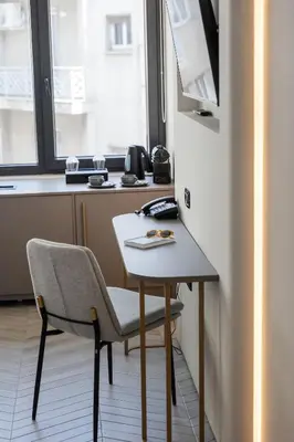 a small table and chair in a room with a window at Esse Athens in Athens