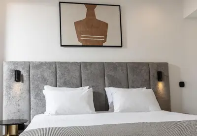 a bedroom with a large bed with white pillows at Esse Athens in Athens