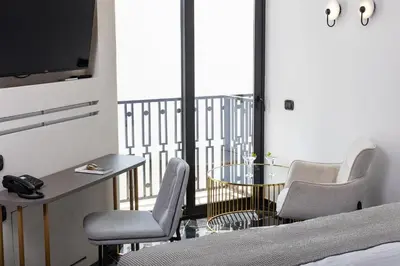 a room with chairs and a table and a balcony at Esse Athens in Athens