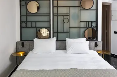 a bedroom with a large white bed with mirrors at Esse Athens in Athens