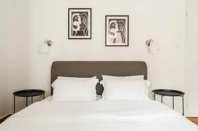a bedroom with a white bed with two tables at YestayHomes Two Bedroom Apartment Tsakalof in Athens
