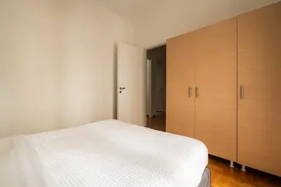 a bedroom with a white bed and wooden cabinets at YestayHomes Two Bedroom Apartment Tsakalof in Athens