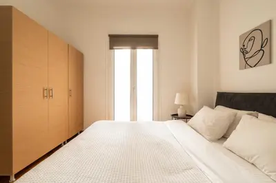 a bedroom with a large bed and a large window at YestayHomes Two Bedroom Apartment Tsakalof in Athens