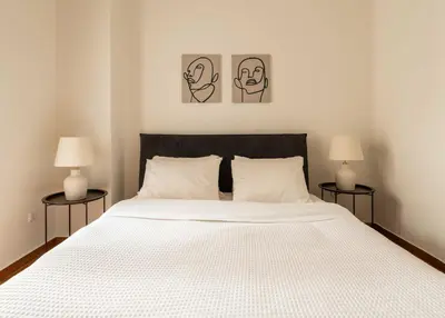 a bedroom with a large white bed with two lamps at YestayHomes Two Bedroom Apartment Tsakalof in Athens