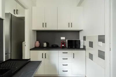 a kitchen with white cabinets and a microwave at YestayHomes Two Bedroom Apartment Tsakalof in Athens