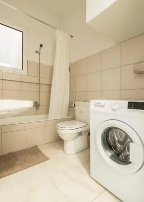 a bathroom with a washing machine and a toilet at YestayHomes Two Bedroom Apartment Tsakalof in Athens