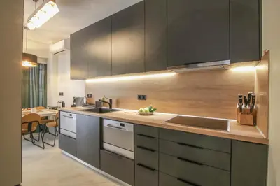 a kitchen with black cabinets and a sink and a table at The Urban Utopia at Glyfada in Athens
