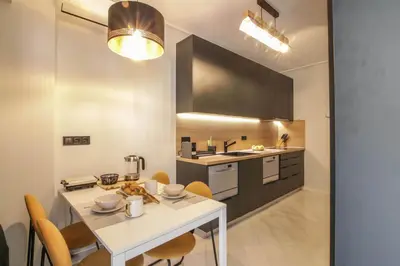 a kitchen with a white table and chairs in a room at The Urban Utopia at Glyfada in Athens