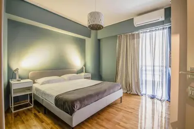a bedroom with a bed and a large window at The Urban Utopia at Glyfada in Athens