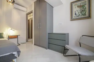 a bedroom with a bed and a chair and a cabinet at The Urban Utopia at Glyfada in Athens