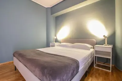 a bedroom with a large bed with blue walls at The Urban Utopia at Glyfada in Athens
