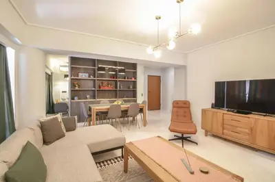 a living room with a couch and a flat screen tv at The Urban Utopia at Glyfada in Athens