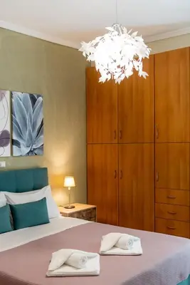 a bedroom with a bed and a chandelier at Blue Ark Exploring Athens in Athens