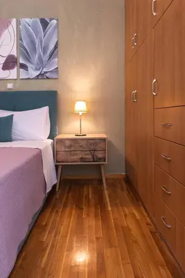 a bedroom with a bed and a night stand with a lamp at Blue Ark Exploring Athens in Athens