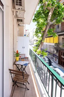a balcony with a table and chairs and a street at Blue Ark Exploring Athens in Athens