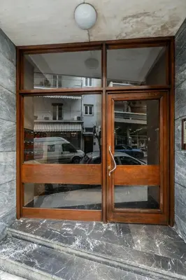 a wooden door in a building with windows at Rovertou Galli 3-5 by Athens Concept Residences in Athens