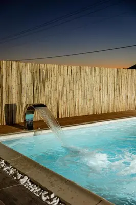 a swimming pool with a water fountain at Σπίτι με πισίνα δίπλα στο αεροδρόμιο. in Spáta