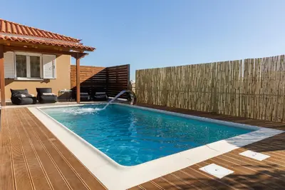 a swimming pool with a water fountain in a backyard at Σπίτι με πισίνα δίπλα στο αεροδρόμιο. in Spáta