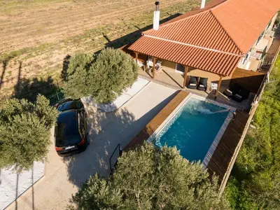 an overhead view of a house with a car parked next to a pool at Σπίτι με πισίνα δίπλα στο αεροδρόμιο. in Spáta